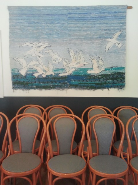 Verdandi main room Weaving of seagulls hanging above rows of chairs at Verdandi women's center, Fittja